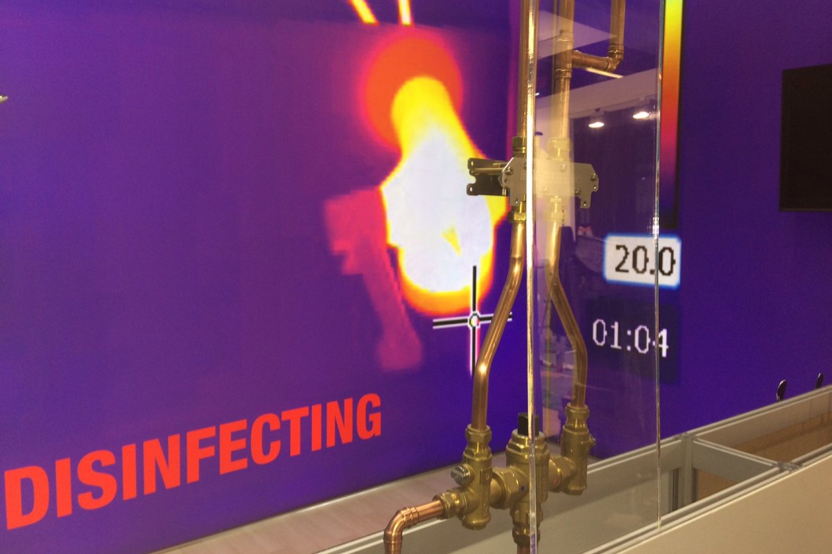 Horne exhibition stand ISH 2019 - foreground shows patented In-Line thermal disinfection unit, ILTDU, feeding 4th Connnection Horne 15 thermostatic mixing valve and thermal image backdrop Horne Optitherm thermostatic tap undergoing thermal disinfection via ILTDU