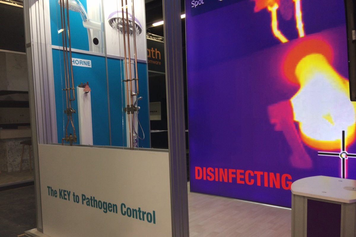 Horne exhibition stand ISH 2019 - foreground shows ILTDU, In-line Thermal Disinfection Unit feeding Horne 15 TMV and Horne Optitherm thermostatic tap in foreground and Horne pre-plumbed shower panels with integral ILTDU in background